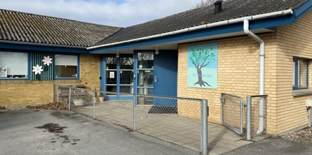 Indgang til Hyldebærhuset hus med gule mursten, sort tag og blå døre og vinduer.