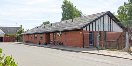 Indgangspartiet til daginstitutionen Svalen i Næstved Kommune. Huset er en lang bygning opført i røde mursten. 